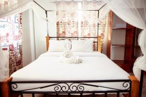 a bedroom with a bed with a teddy bear on it at Kitopua suites in Arusha