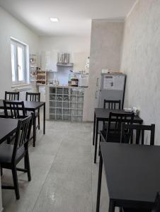 a dining room with tables and chairs and a kitchen at Bed and Breakfast Mezzanotte in Balvano +14 photos
