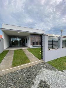 a large white building with a driveway at Casa com piscina praia do ervino in São Francisco do Sul