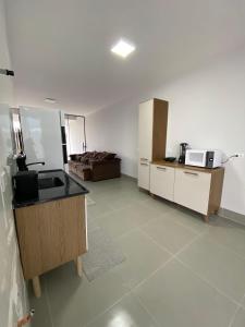 a room with a kitchen with a sink and a microwave at Casa com piscina praia do ervino in São Francisco do Sul