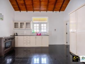 a kitchen with white cabinets and a window at Azure Heaven Villa in Wennappuwa