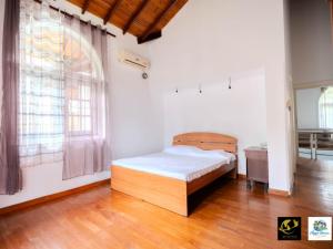 a bedroom with a bed and a large window at Azure Heaven Villa in Wennappuwa