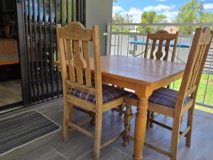a wooden table and two chairs on a porch at Klaas Vakie Guesthouse in Beaufort West