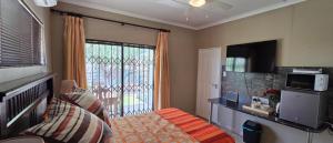 a living room with a bed and a television at Klaas Vakie Guesthouse in Beaufort West +17 photos
