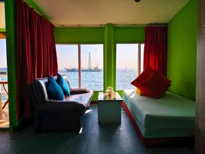 a room with a couch and a window with the water at Lareena Resort Koh Larn Pattaya in Ko Larn