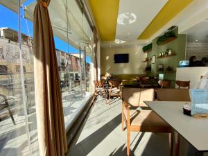 a room with a table and chairs and a large window at Selez Aparthotel & Residence in Durrës