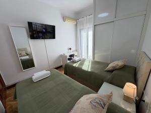 a room with two green beds and a mirror at Habitaciones en Don Ramon in Madrid