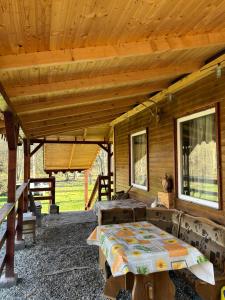 a wooden cabin with a bed and windows at Cabana Buta in Dumeşti