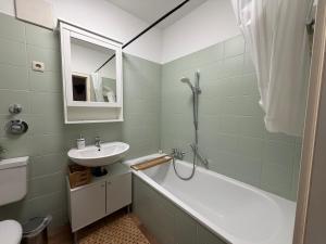 a bathroom with a sink and a bath tub and a mirror at Ferienwohnung am Altmarkt, für bis zu 4 Personen, 55qm in Cottbus