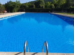 a large blue swimming pool with blue water at Bungalows Prados Abiertos in Mombeltrán