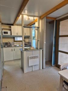 a kitchen with white cabinets and a counter top at Bungalows Prados Abiertos in Mombeltrán