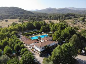an aerial view of a resort with a pool and trees at Bungalows Prados Abiertos in Mombeltrán