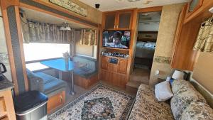 an interior of an rv with a table and a tv at Starry Skies RV in Victoria