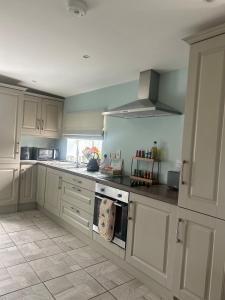 a kitchen with white cabinets and a stove top oven at Clontrain Cottage in Carrickmacross