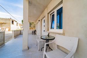 a patio with chairs and a table and a window at Rooms & Apartments Mirakul in Vela Luka