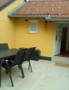 a table and chairs in front of a yellow house at Samobor Old Town Studio by the River in Samobor +7 photos