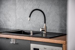 a kitchen sink with a faucet on a counter at Apartamenty Przystanek Bańska in Bańska Niżna +62 photos