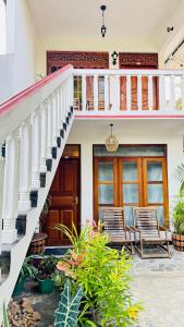 a house with two chairs and a staircase at Royal Villa in Ahangama