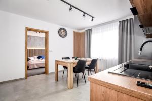 a kitchen and dining room with a table and chairs at Apartamenty Przystanek Bańska in Bańska Niżna