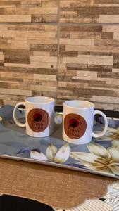two coffee mugs sitting on a tray on a table at Casa do João in Maricá