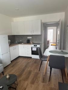 a kitchen with white cabinets and a table and chairs at Apartmán LUNA Choceň in Choceň