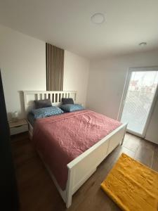 a bedroom with a large bed with a red blanket at Apartmán LUNA Choceň in Choceň