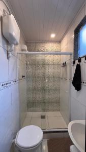 a bathroom with a shower with a toilet and a sink at Casa do João in Maricá