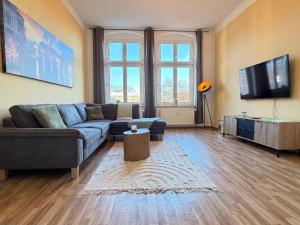 a living room with a couch and a flat screen tv at Ferienwohnung am Altmarkt, für bis zu 4 Personen, 55qm in Cottbus