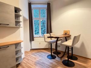 a kitchen with a table and two chairs and a window at Ferienwohnung am Altmarkt, für bis zu 4 Personen, 55qm in Cottbus +10 photos