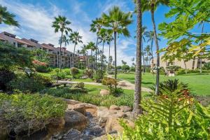 a resort with palm trees and a creek at Kamaole Sands 1101 · KAS 1101 Updated Beachy Chic 2BD Across Bea in Wailea