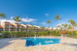 a resort swimming pool with palm trees in the background at Kamaole Sands 1101 · KAS 1101 Updated Beachy Chic 2BD Across Bea in Wailea