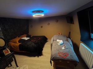 ein Zimmer mit zwei Betten und blauem Licht in der Unterkunft L'instant pause douceur in Blendecques