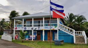 a blue and white house with a flag on it at Treehouse Apartment at La Lodge at Long Bay in Corn Islands
