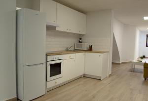 a kitchen with white cabinets and a stove top oven at Suites TDJ Centro in Torredonjimeno +18 photos
