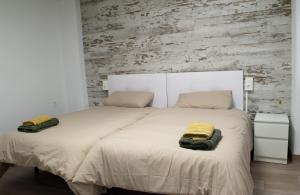 a bedroom with a large bed with two towels on it at Suites TDJ Centro in Torredonjimeno