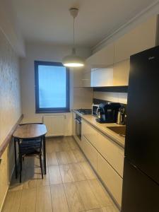 a small kitchen with a table and a table and a chair at Alex MNL lux Apartment 2 free parking in Bucharest