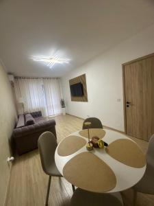 a living room with a table and chairs and a couch at Alex MNL lux Apartment 2 free parking in Bucharest