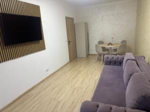 a living room with a purple couch and a table at Alex MNL lux Apartment 2 free parking in Bucharest