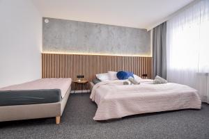 a bedroom with two beds and a window at Apartamenty Przystanek Bańska in Bańska Niżna