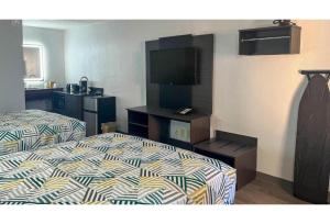 a hotel room with a bed and a flat screen tv at Studio 6 Spindale, NC Forest City in Spindale