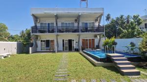 a house with a swimming pool in front of it at Jkl MahaOya Villa in Wayikkal