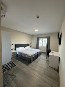 a bedroom with a large bed and a desk and a window at Hotel El Cisne - parking exterior gratuito in Zaragoza +106 photos