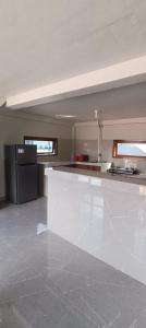 a kitchen with a white counter and a black refrigerator at Toraja Hikari Homestay in Rantepao