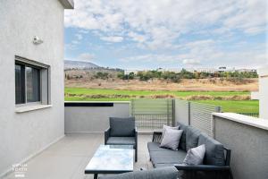 a balcony with a couch and chairs and a table at פסגת יובלים 2 in Qiryat Shemona