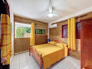 a bedroom with a bed with yellow sheets and a window at Uta Houses in Baie-Mahault +56 photos