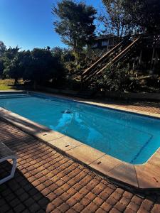 a swimming pool with blue water next to a house at Banabaka spa and venue in White River