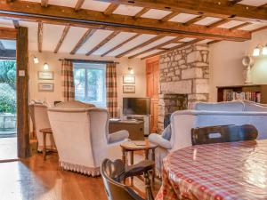 a living room with chairs and a stone fireplace at Pebbles in Castletown