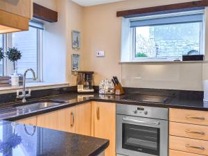 a kitchen with a sink and a stove at Pebbles in Castletown