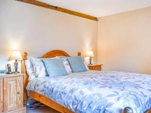 a bedroom with a bed and two night stands at Pebbles in Castletown +8 photos