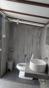 a bathroom with a white toilet and a sink at Sunshine's Hill in Ko Lanta +35 photos